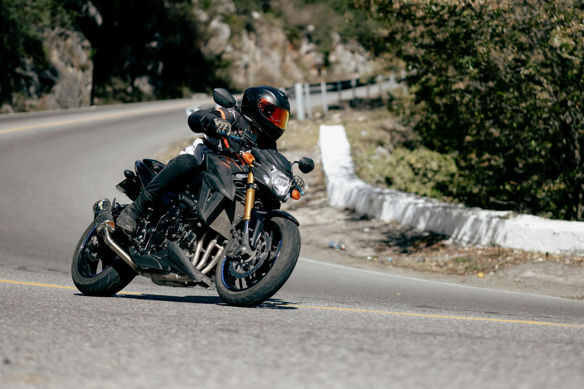 Motocyklista pokonuje ostry zakręt na górskiej drodze w San Luis Potosí