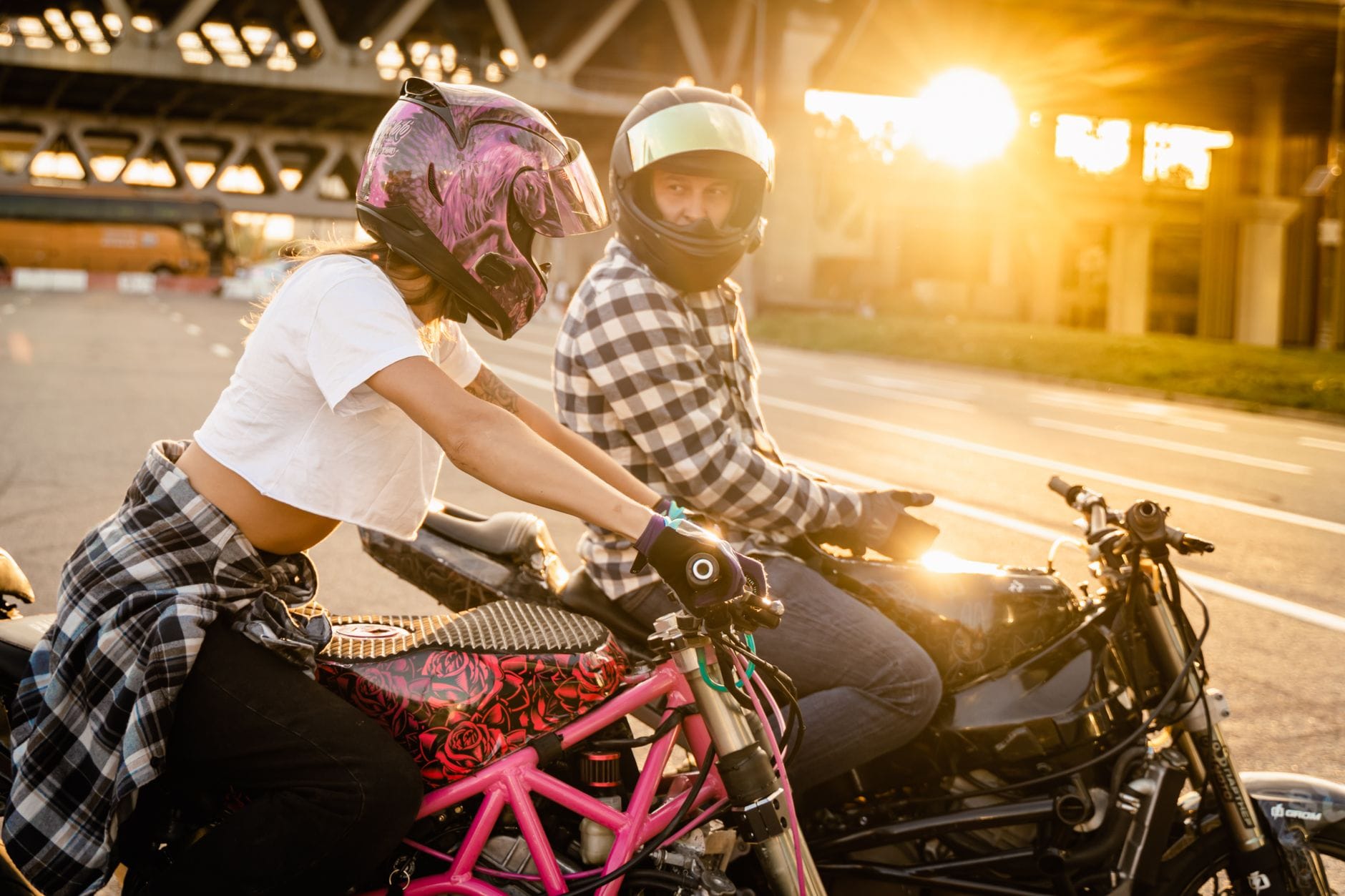 Para motocyklistów jedzie po mieście o zachodzie słońca