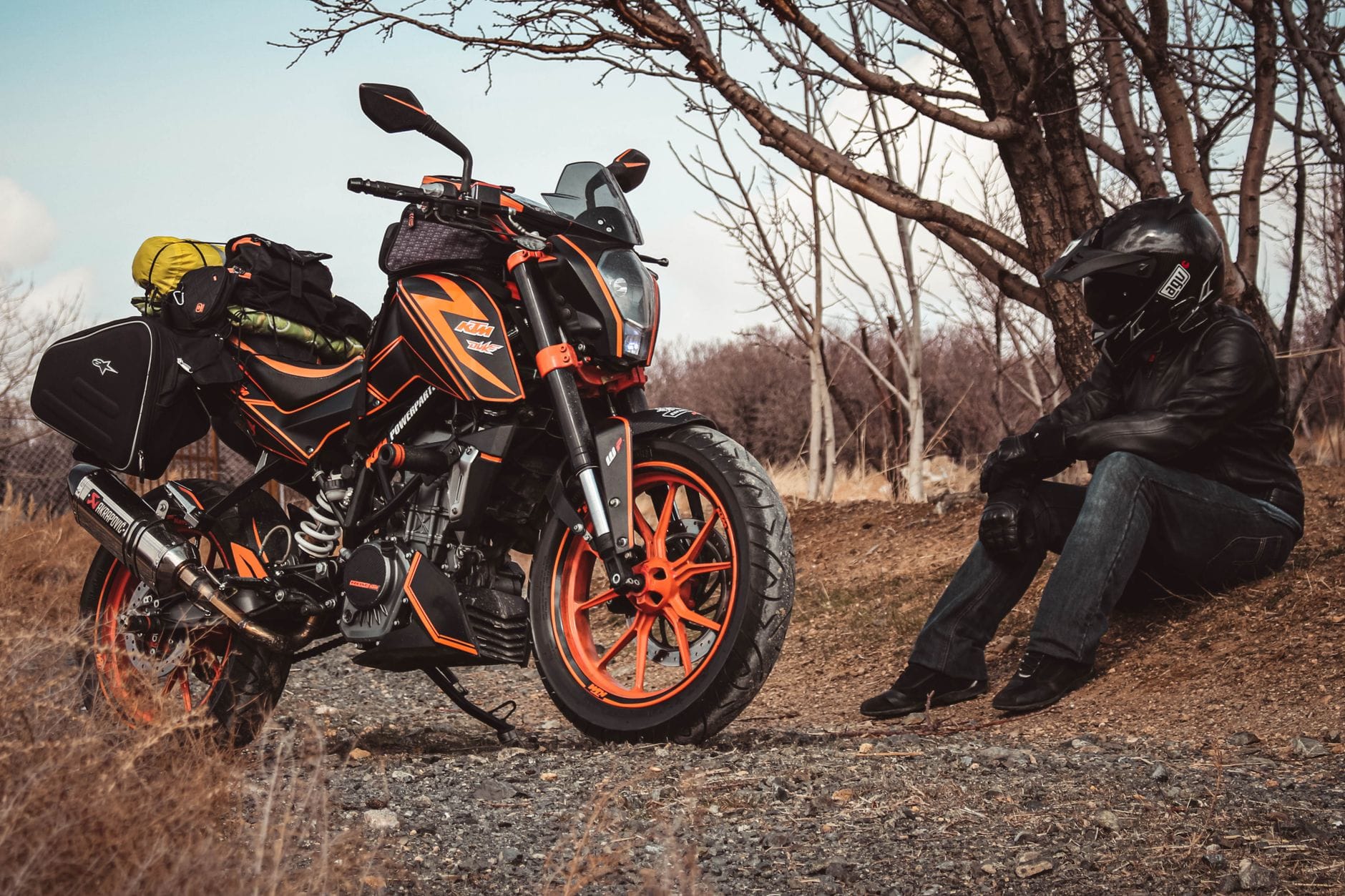 Motocyklista przy zapakowanym turystycznym KTM na wiejskiej drodze